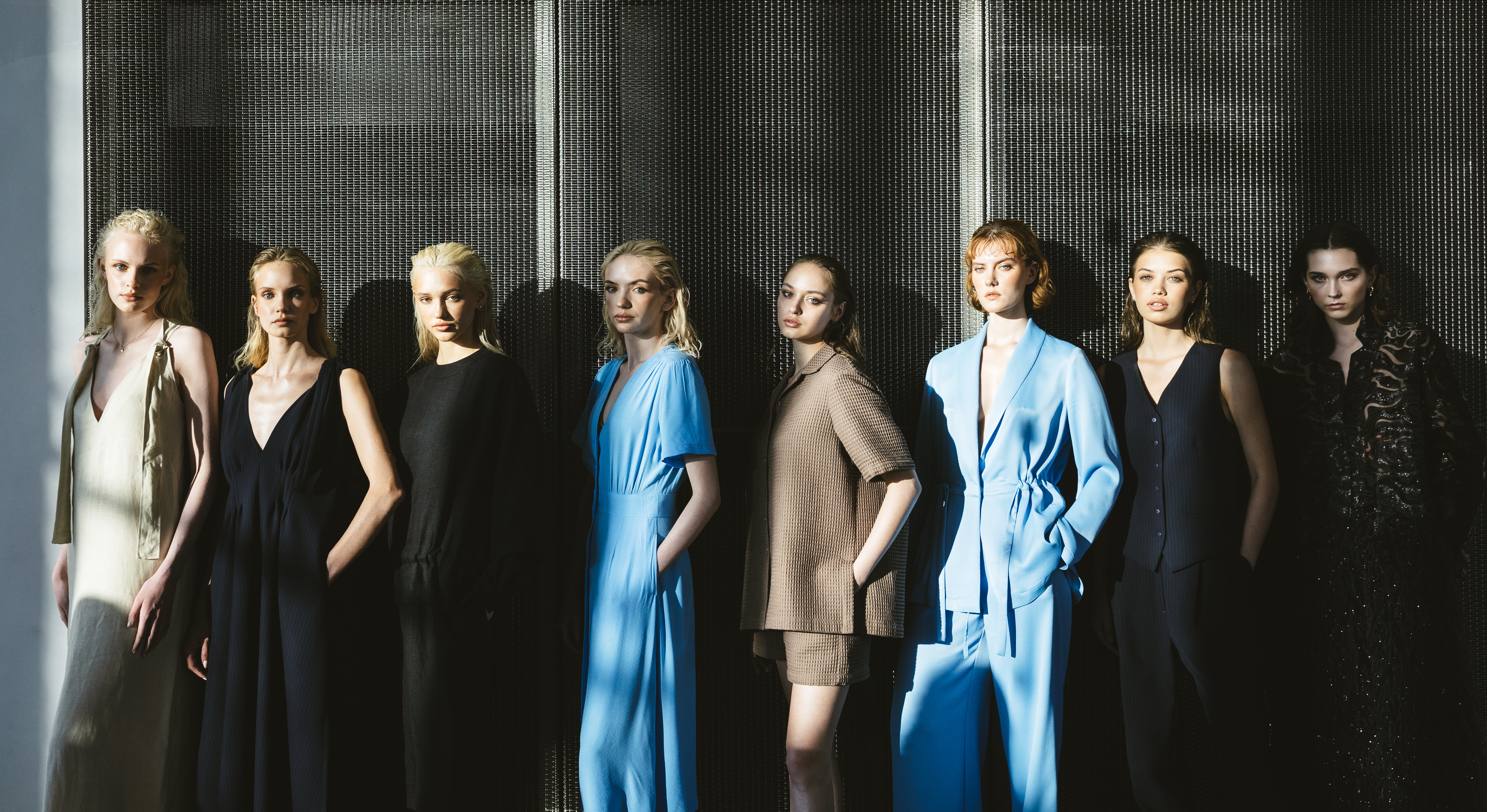 Female models posing in front of a wall